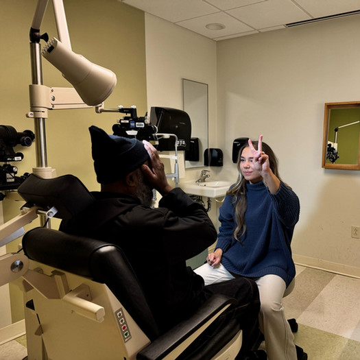 student doctor holding up two fingers for optometry patient