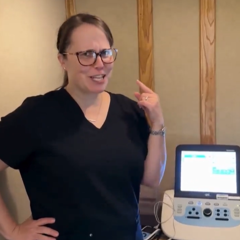 Dr. Bondurant standing in a hearing exam booth