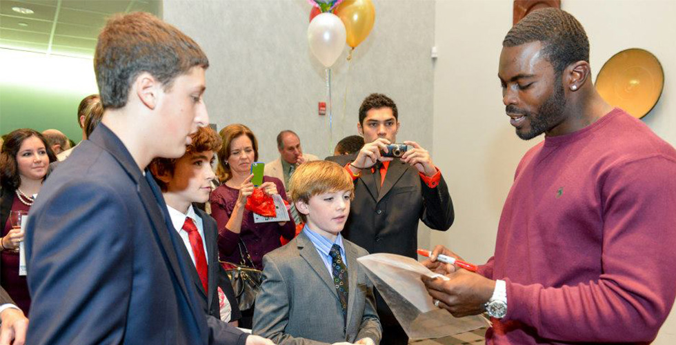 Michael Vick gives attendees his autograph