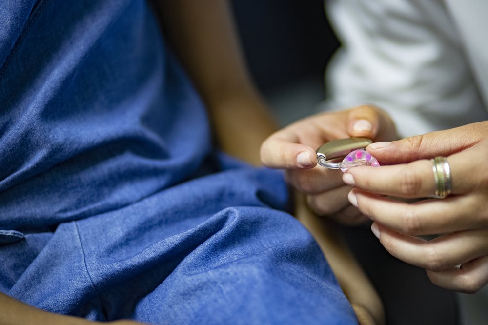 person holding a hearing aid