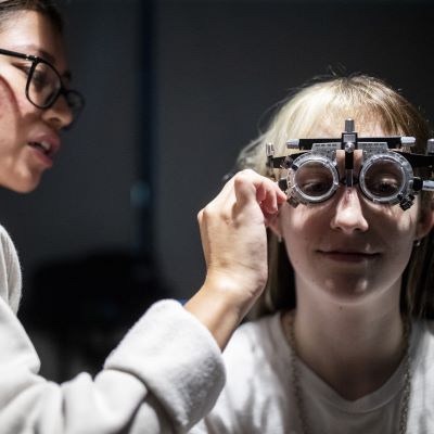 Optometrist conducting eye exam on a young girl