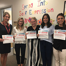 students holding Better Hearing & Speech Month papers