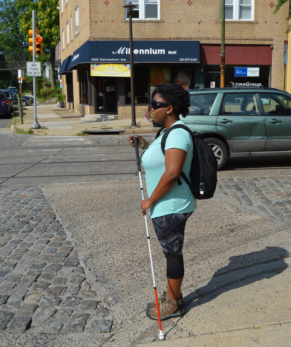 Woman walking with a white mobility cane