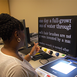 Patient using a low vision device at the Feinbloom Center