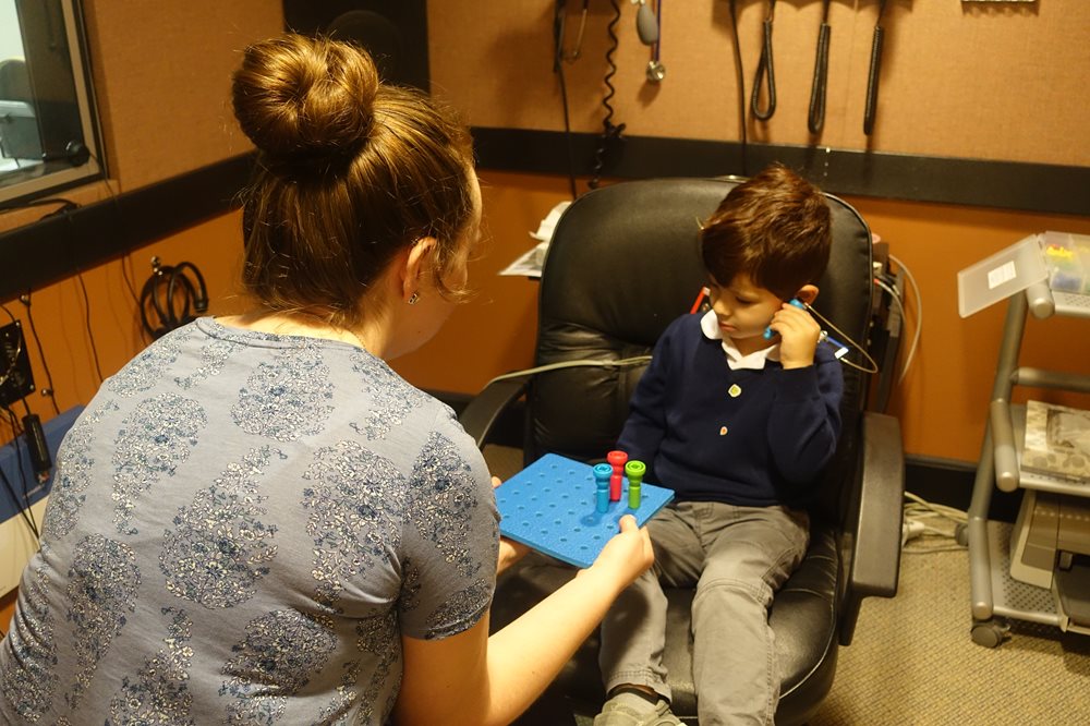 Young boy with pegs for hearing test