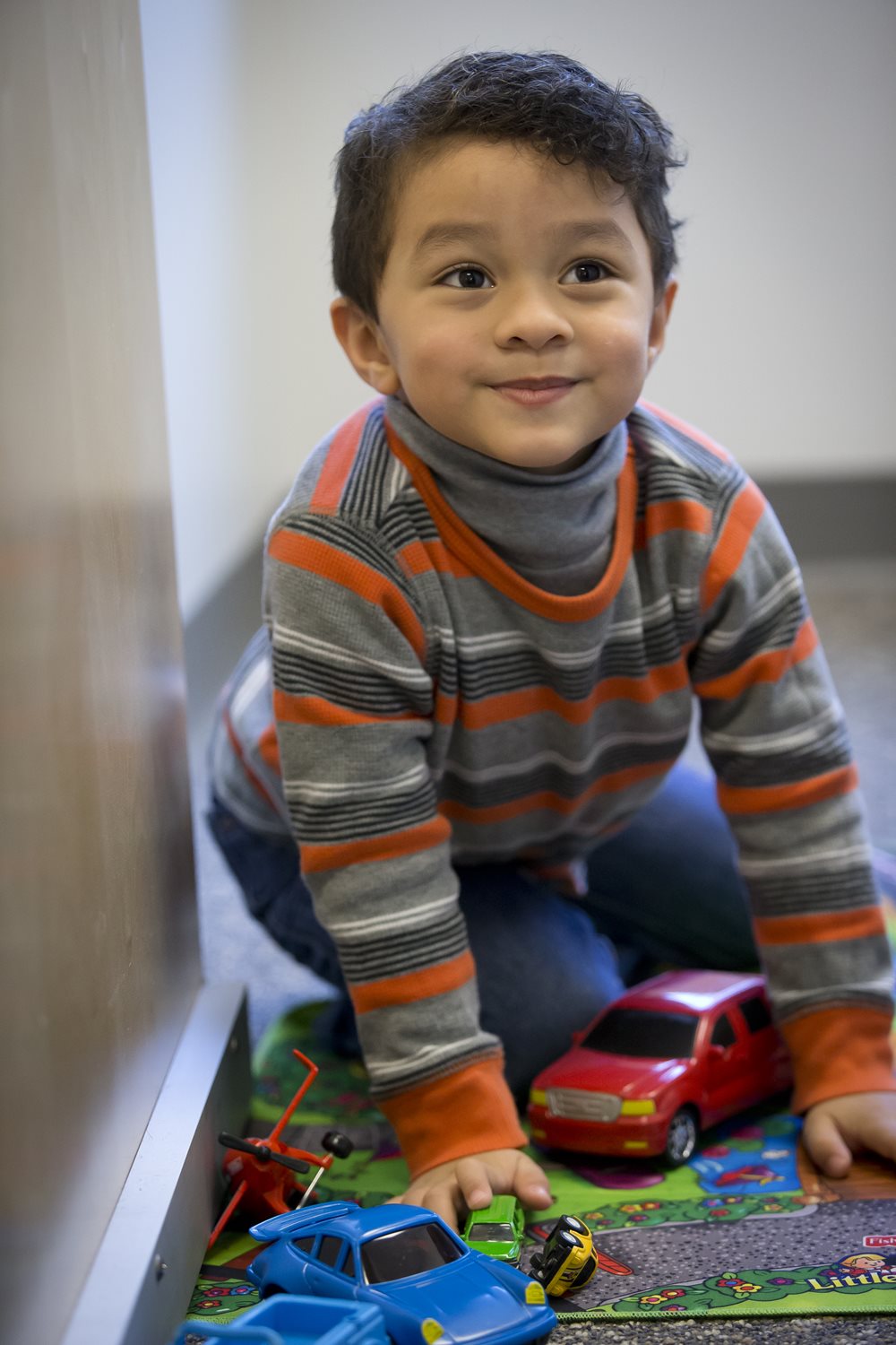 Young boy playing with toy cars