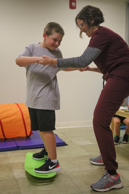 Brianna & pediatric OTI client on balance board