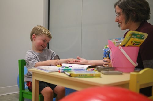 Brianna Brim with young boy coloring