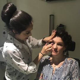 Optometrist putting contact lens in patient's eye