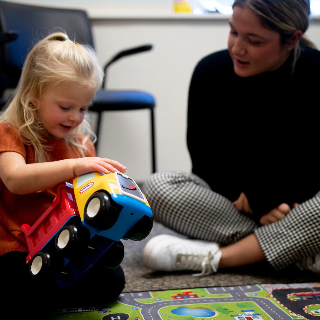 Student with child playing with a truck