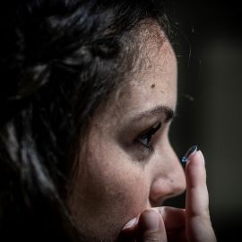 Woman putting in contact lens