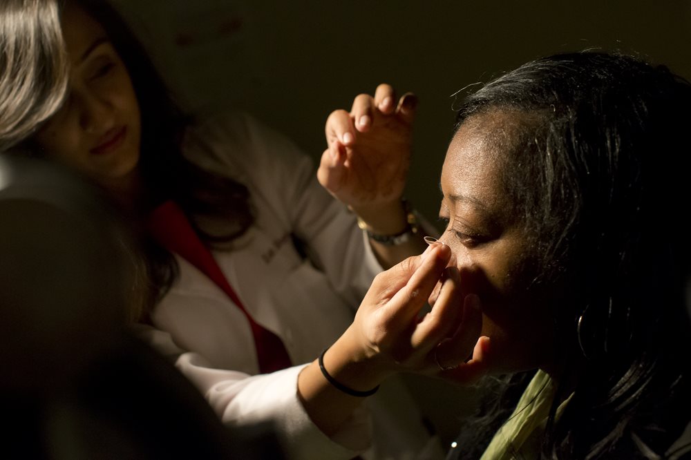 Doctor placing contact lens in patient