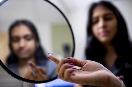 Woman putting in contact lens