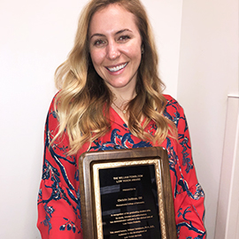 Dr. DeMoss holding her award