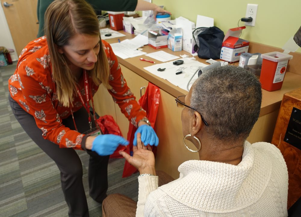 Woman having blood sugar tested