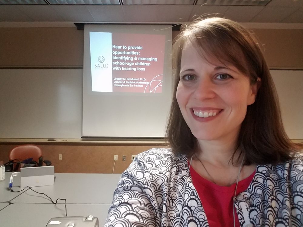 Dr. Bondurant selfie in front of her presentation