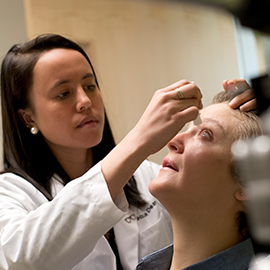 Optometrist giving eye drops to patients