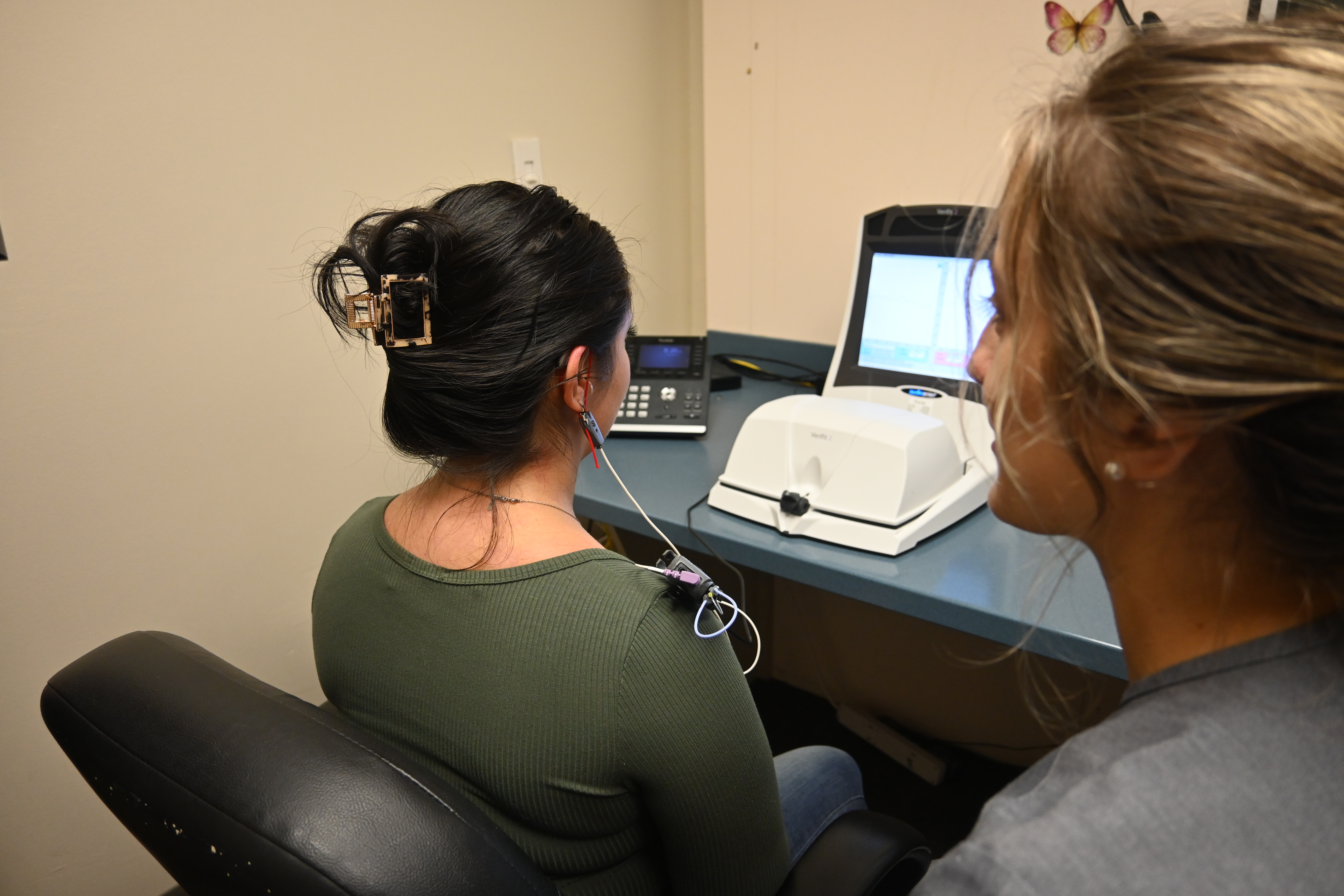 Woman sitting with listening device on 