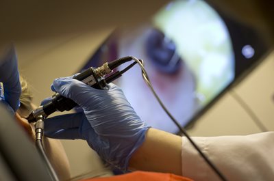 audiologist holding a device to look inside a patients ear