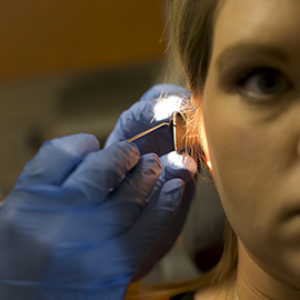 Woman having earwax removed