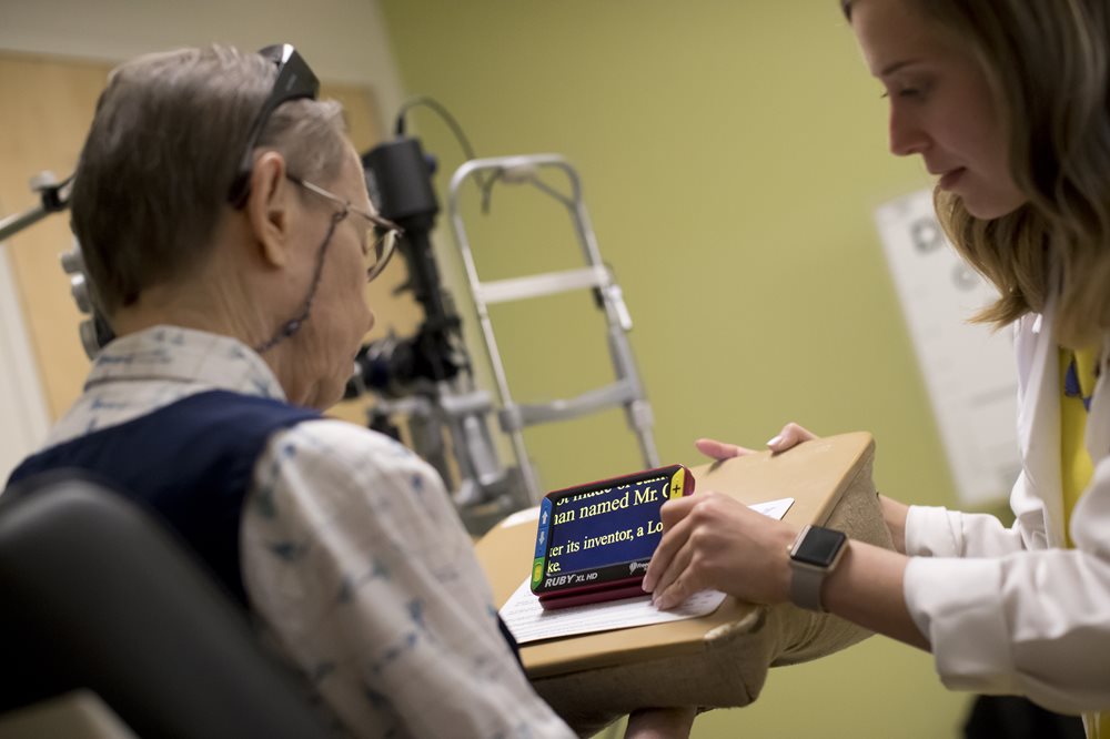 Male patient using a low vision device at the Feinbloom Center