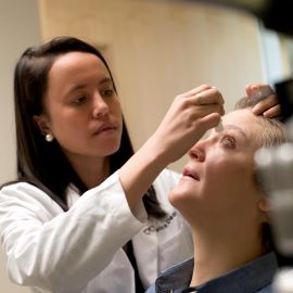 Doctor putting drops in patient's eyes