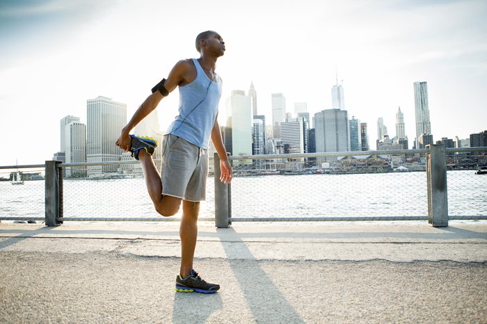 Man stretching with the New York skyline in the background