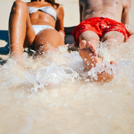 man and woman lying on the beach