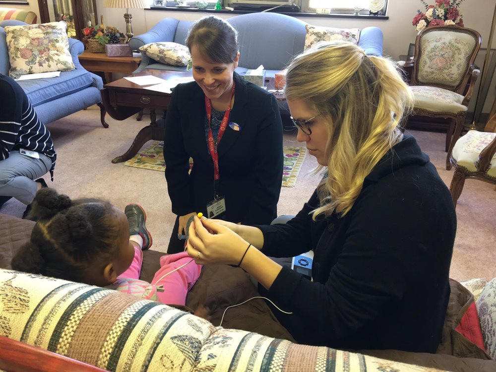 Dr. Bondurant and audiology student examining young girl