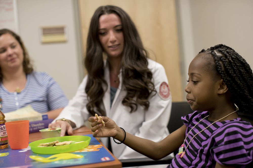 young girl with speech language pathologist