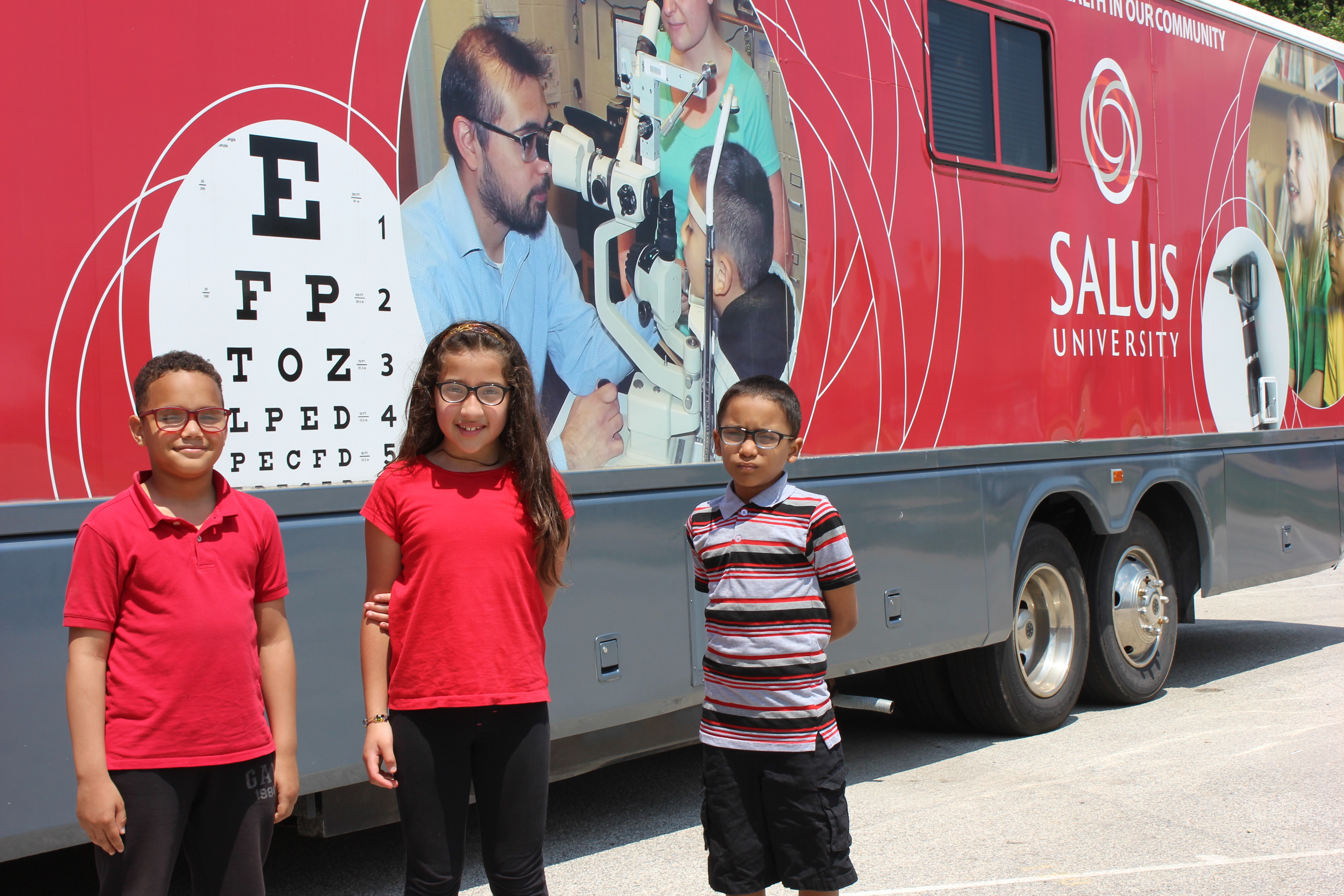 Students standing in front of the Big Red Bus