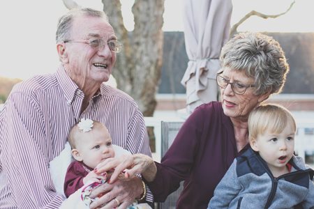 grandparents holding their two grandchildren