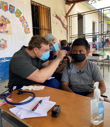 Salus student checking Guatemalan boy