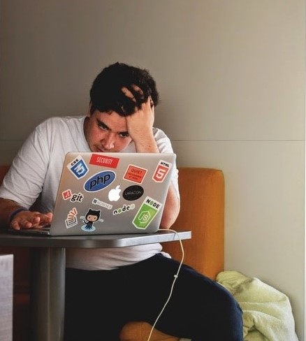 young man looking stressed at computer