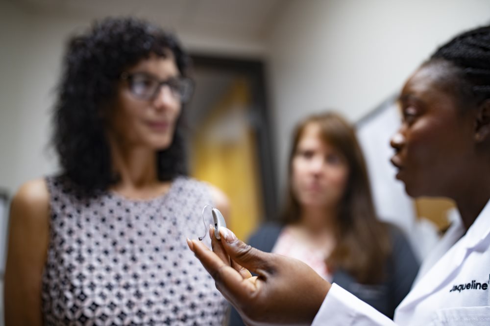 Audiologist holding hearing aid