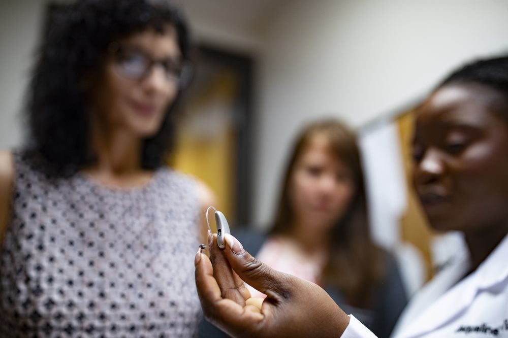 audiologist showing patient a hearing aid