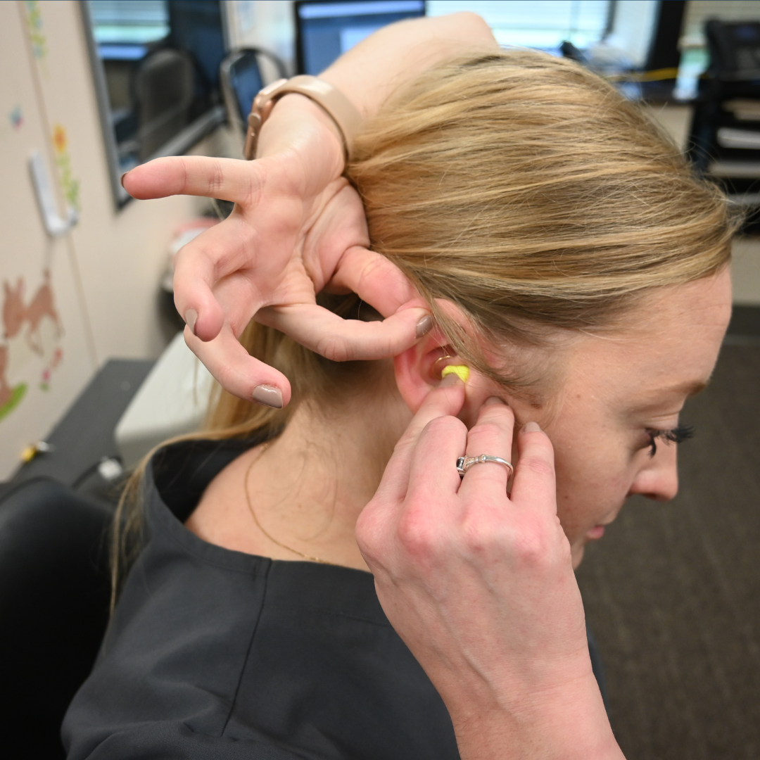 Woman trying on earplugs 