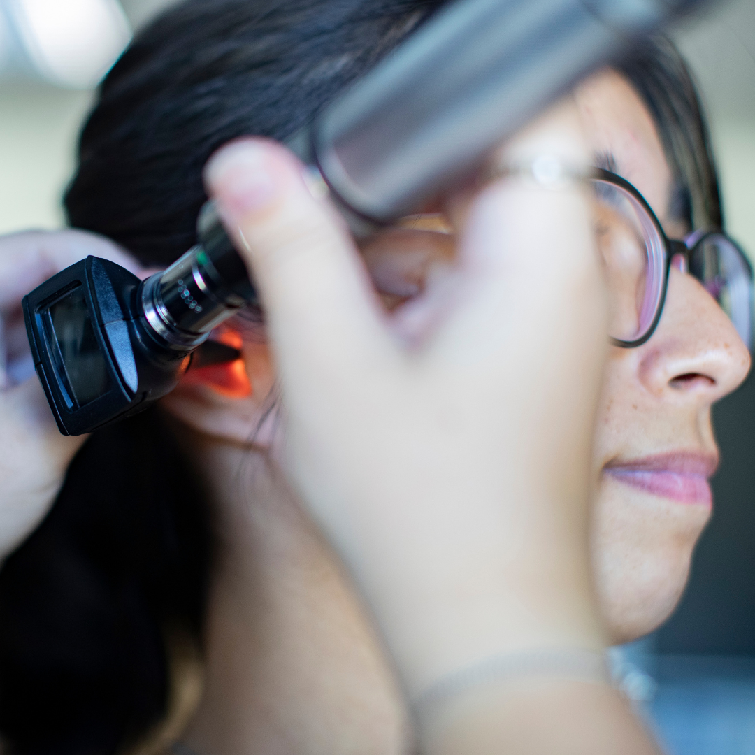 Woman getting ears checked with audiology instrument