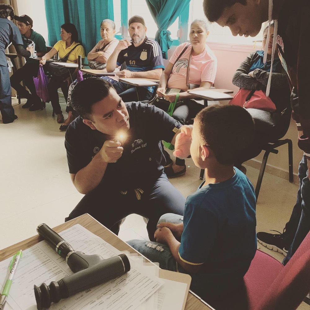 Dr. Higa giving an eye exam to a young boy