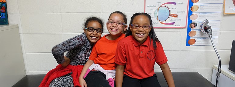 Three children smiling in the nurses office