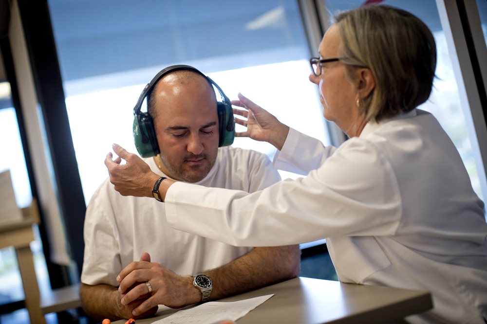 man with headphones working with an audiologist