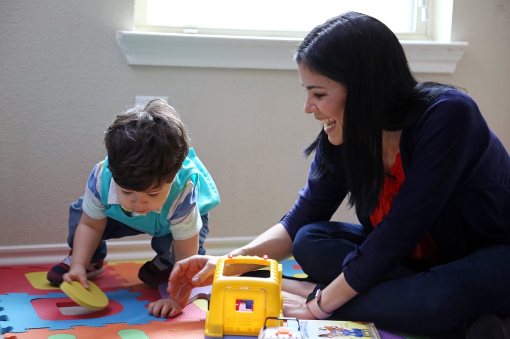 Mother and son playing with toy trucks