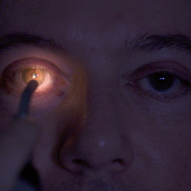 Man having eye examined with light