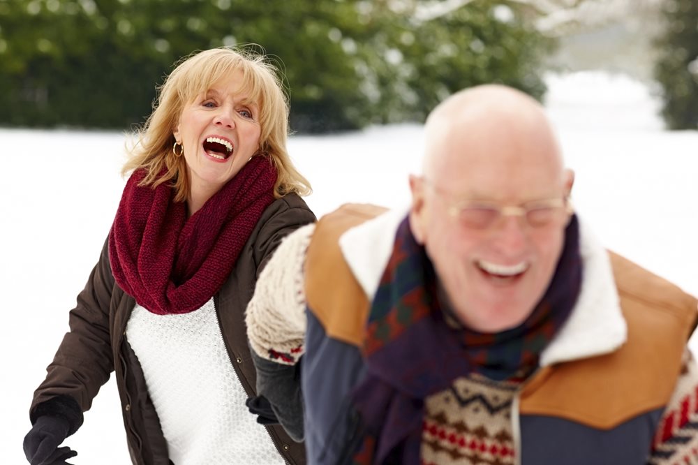 Older couple running in the snow