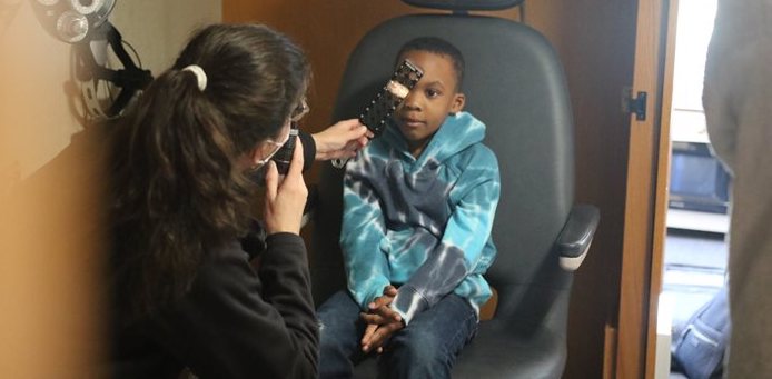 Dr. Scombordi-Raghu and pediatric patient eye exam on the Big Red Bus