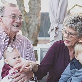 Elderly couple holding 2 grandkids