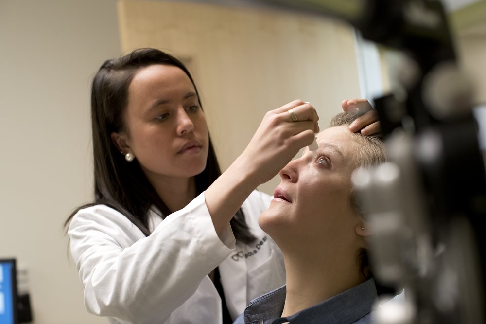 Optometry student giving eye drops