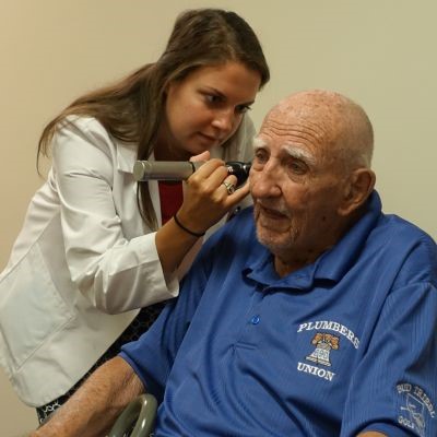 Student examining older patient thumb1