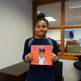 Milan Smalls holding her book