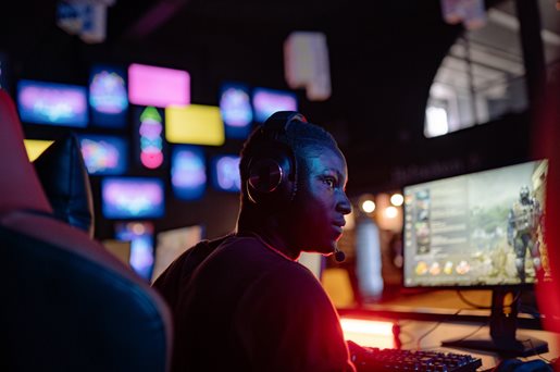 Gamer wearing headphones sitting in front of a computer